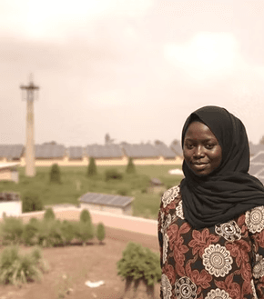 Woman standing before a solar farm installation in Nigeria